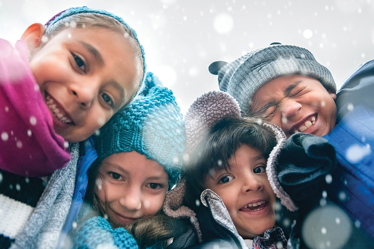 Children smiling at camera in snow